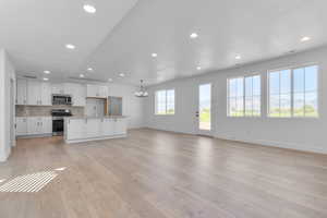 Kitchen featuring white cabinetry, recessed lighting, a chandelier, backsplash, and stainless steel appliances