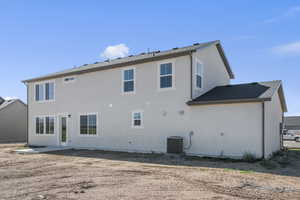 Rear view of house featuring a patio area, stucco siding, and a shingled roof