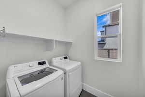 Laundry area featuring separate washer and dryer and baseboards