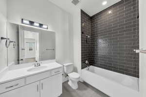 Full bath with shower / bathtub combination, vanity, light tile patterned flooring, and recessed lighting