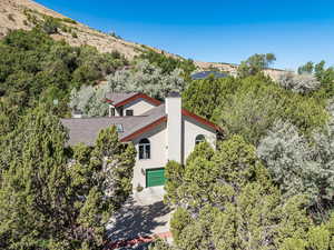 Aerial view of property and surrounding area with a tree filled landscape