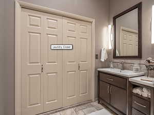 Bathroom featuring vanity and a closet