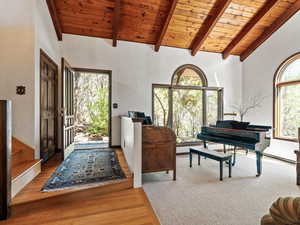 Foyer with a wooden ceiling with exposed beams, wood finished floors, and high vaulted ceiling