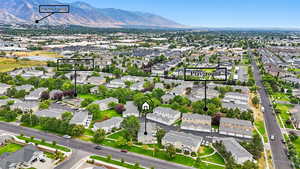 Aerial view of residential area featuring property boundaries highlighted and a mountain backdrop