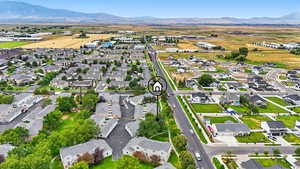 Aerial view of property and surrounding area with nearby suburban area and mountains