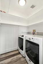 Laundry area with dark wood-type flooring and independent washer and dryer