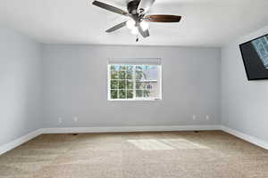 Empty room with light carpet and a ceiling fan