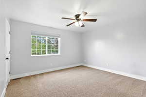 Unfurnished room featuring light colored carpet and ceiling fan