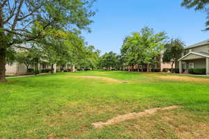 View of grassy yard with covered porch