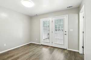 Doorway with wood finished floors and baseboards