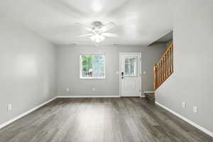 Foyer entrance featuring stairway, wood finished floors, and a ceiling fan