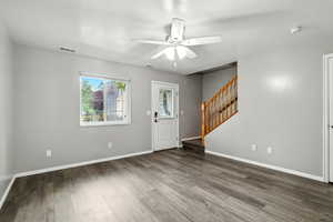 Entrance foyer with stairway, ceiling fan, and wood finished floors