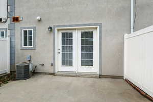 View of exterior entry with stucco siding and a patio