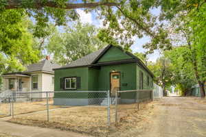 View of front of property with a shingled roof, a gate, and a fenced front yard