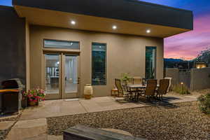 Patio terrace at dusk with a patio area, area for grilling, and french doors