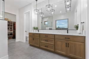 Bathroom with a shower stall, a spacious closet, double vanity, recessed lighting, and light tile patterned floors