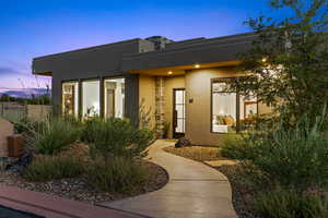 Exterior entry at dusk with stucco siding