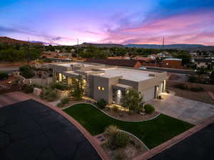View of front of home featuring stucco siding, an attached garage, driveway, a mountain view, and a residential view