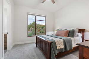 Carpeted bedroom featuring lofted ceiling and ceiling fan