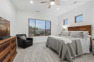 Bedroom with light colored carpet, ceiling fan, and recessed lighting