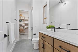 Bathroom featuring vanity, a stall shower, and dark tile patterned flooring