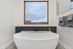 Bathroom with a soaking tub and tile patterned floors