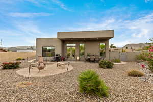 Back of house featuring a patio area, a mountain view, a fenced backyard, and stucco siding