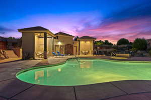 Pool at dusk featuring a patio