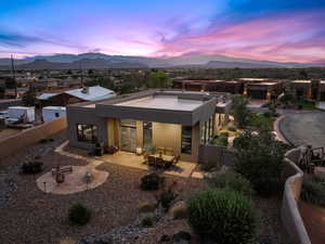 Back of property with stucco siding, a patio area, a fenced backyard, and a mountain view