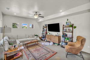 Living room featuring carpet floors, recessed lighting, ceiling fan, and a textured ceiling