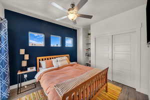 Bedroom with wood finished floors, a ceiling fan, and a closet
