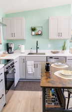 Kitchen with appliances with stainless steel finishes, white cabinets, and under cabinet range hood