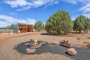 View of yard with a fire pit, a pole building, and an outdoor structure