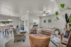 Living area featuring a textured ceiling, recessed lighting, light tile patterned floors, and ceiling fan