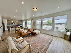 Living room featuring healthy amount of natural light, recessed lighting, and light wood-style floors