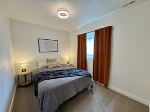 Bedroom featuring carpet floors and a textured ceiling