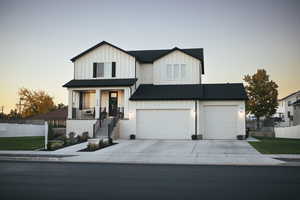 Modern farmhouse style home featuring board and batten siding, covered porch, driveway, and an attached garage