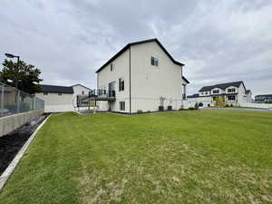 Rear view of property with stucco siding and a balcony