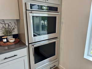 Kitchen featuring stainless steel double oven and white cabinetry