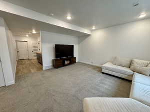 Living room with light colored carpet and recessed lighting