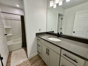 Bathroom featuring vanity, light wood-style flooring, and shower / bath combo with shower curtain