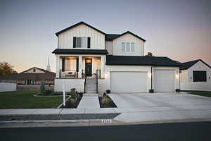 Modern farmhouse style home featuring board and batten siding, covered porch, driveway, and a garage