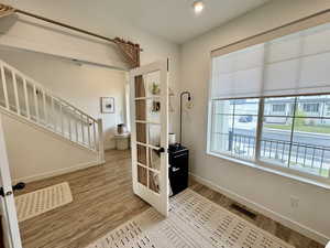 Foyer entrance with stairs, wood finished floors, and recessed lighting