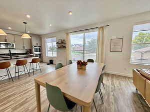 Dining area featuring light wood-style flooring, recessed lighting, and a textured ceiling