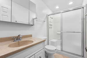 Full bath with a stall shower, vanity, light tile patterned floors, and recessed lighting