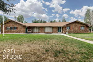 Ranch-style home with brick siding and a front yard