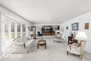 Formal living room featuring crown molding and carpet