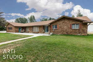 View of front facade featuring brick siding, crawl space, a front yard, and roof with shingles