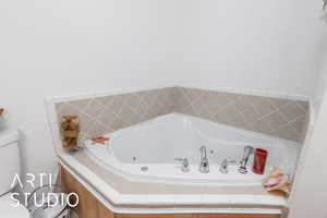 Bathroom with a tub with jets and toilet