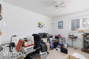 Bedroom featuring light carpet and a ceiling fan (currently being used as an office)